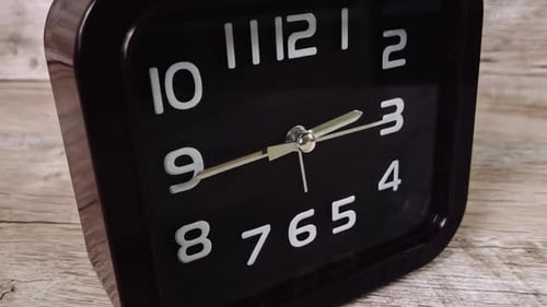 Zeitraffer der Zeigeruhr auf einem Holztisch zeigt die Zeit drehenden Uhrzeiger