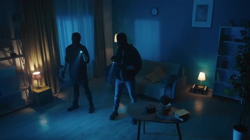Two Masked Burglars with Flashlights Indoors at Night