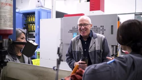 Happy Workers Talking at Machinery in Manufacturing Plant 10 Seconds or Greater