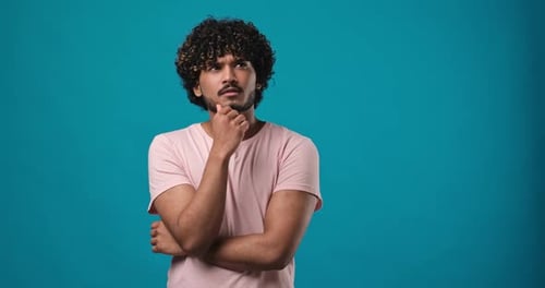 Pleased Thinkful Indian Man is Raisingup His Finger While Coming Up with an Idea Standing Isolated