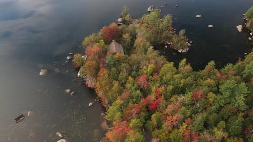 Aerial View of Lake House Hidden in Colorful Lush Forest in Autumn Vivid Colors. Lakefront in Countr