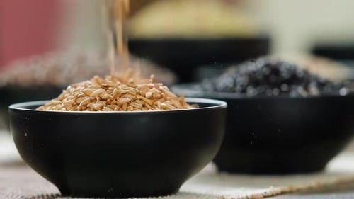 Grains Being Poured Into a Black Bowl