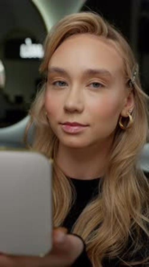 Young Woman Applying Makeup and Checking Appearance