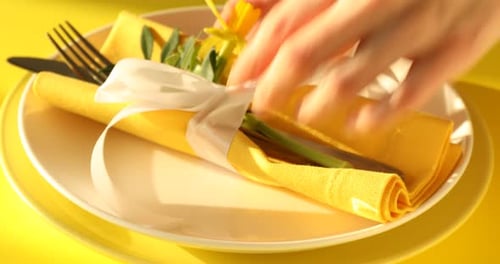 Easter celebration. Woman setting table for festive dinner on yellow background, closeup