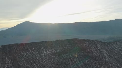 Adventurous hikers walking on the edge of mount bromo volcano crater