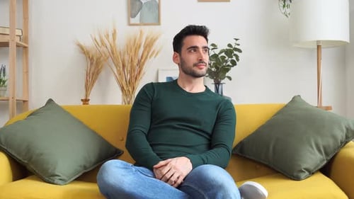 Cheerful Young Man Sitting on Sofa