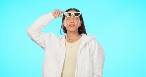 Fashion, sunglasses and portrait of woman with style or modern clothing isolated in a studio blue
