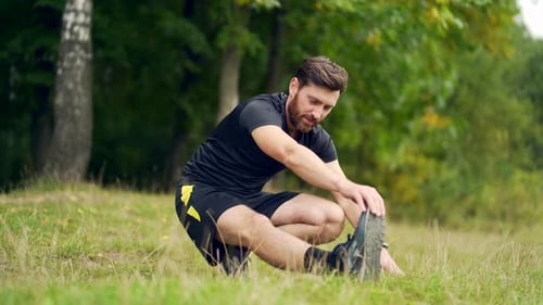 Man Stretching Outside Experiencing Knee Pain