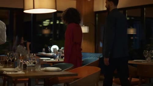 Elegant evening date at luxury hotel restaurant with waiter serving couple