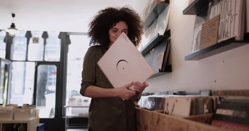 Young Adult female holding record in a store