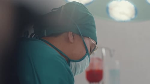 assistants and nurses performing invasive surgery on patient in hospital operating room.