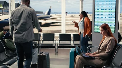 Woman Business Traveler Checking Emails on Laptop in Airport Lounge Corner
