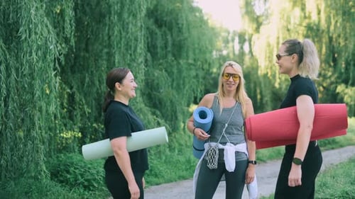 Women Friends with Yoga Mats Outdoors