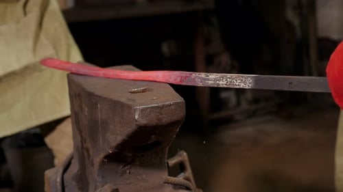 Blacksmith Hammering Red Hot Metal on Anvil