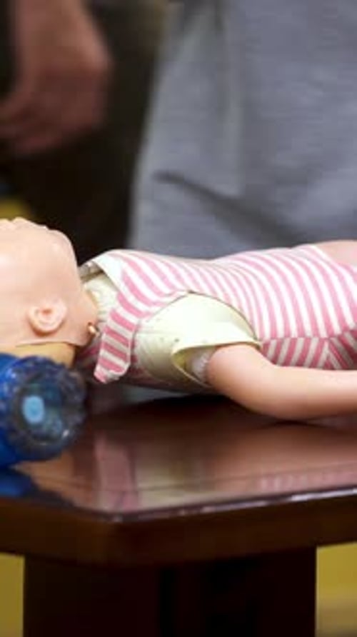 Practicing Infant CPR on a Mannequin Doll