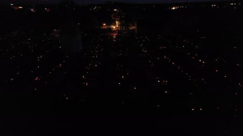Aerial View Of Dark Cemetery Lit By Candles At Night. sideways