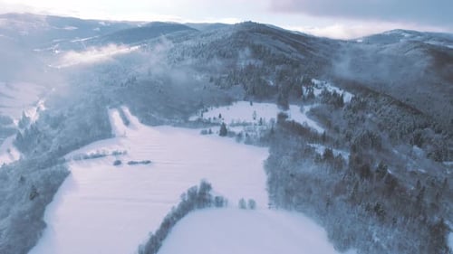 valley covered in fresh white snow during a sunny winter day. Aerial cinematic winter view of high p
