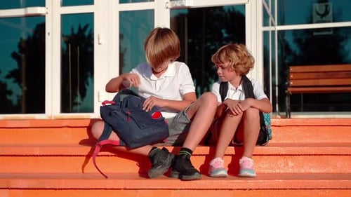 Students Eating Lunch in School Yard During Break Sitting on the Porch