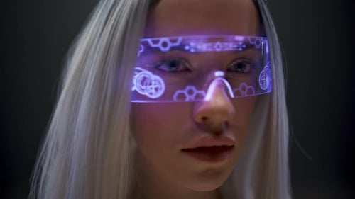 Woman wearing futuristic glasses in a dark room