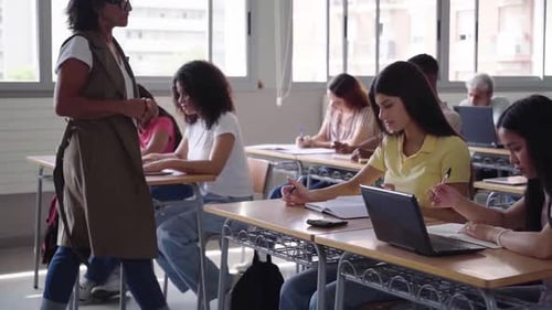 High School Teacher Helping Student During Exam in Classroom