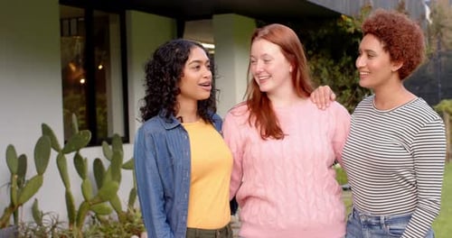 Three Smiling Women Friends Standing Arm-in-Arm