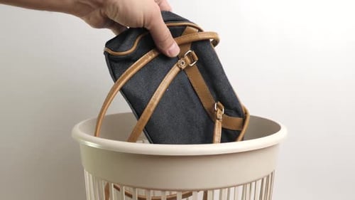 E132. La bolsa de una anciana es arrojada a la basura. Eliminación y reciclaje de residuos.