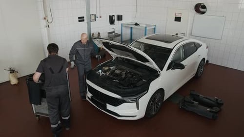 Top View of Two Mechanics Doing Maintenance Work on Car Engine