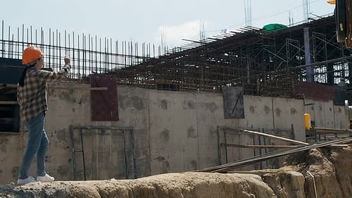 Construction manager and engineer discussing and checking plans on construction site.