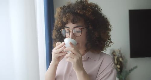Woman Enjoying Coffee by the Window