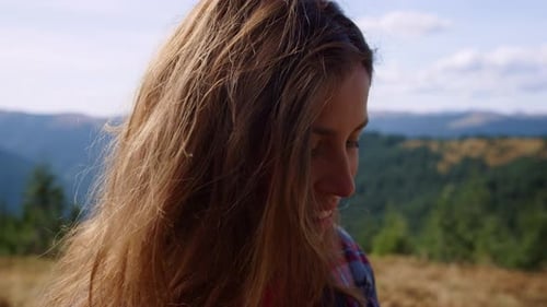 Woman Adjusting Camera in Mountainous Nature Setting