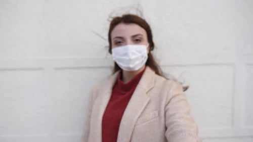 Woman with Facemask Gives Stop Hand Gesture