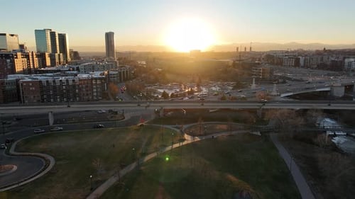Stunning big city aerial shot during golden hour and a huge sunset behind the mountain range