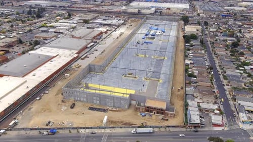 Large warehouse under construction, wide establishing aerial view