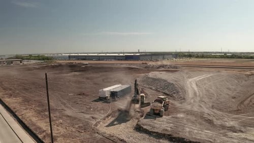 Construction Equipment Moving Dirt on Industrial Site