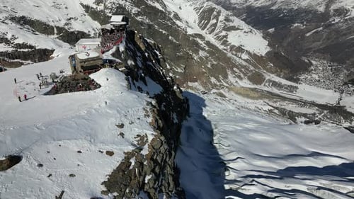 Aerial view of a ski slope in the Swiss alps next to a rocky facade, Saas Fee