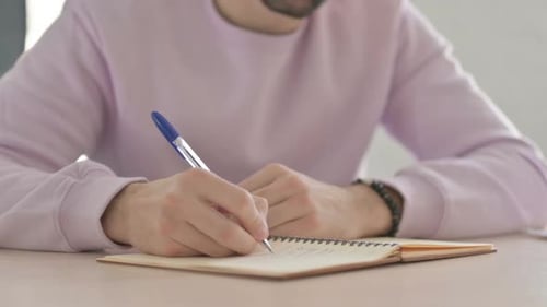 Close Up of Male Hand Writing on Paper