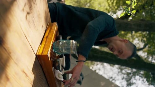 vertical video The hands of a professional tea master who pours fresh natural green tea