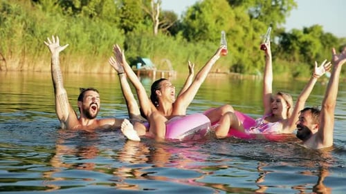 Gruppe junger Freunde, die Spaß haben und einen Sommertag am See genießen.