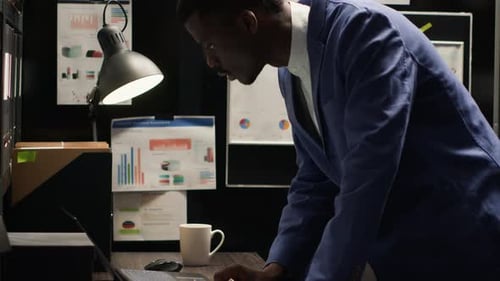 Man Working Overtime on Laptop in Dark Office