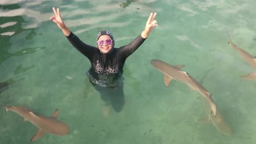 Woman Swimming With Sharks in Tropical Waters