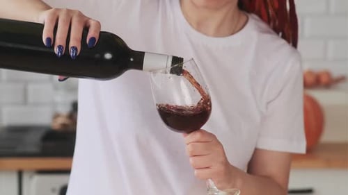 Crop Woman gießt Wein in ein Glas Wein