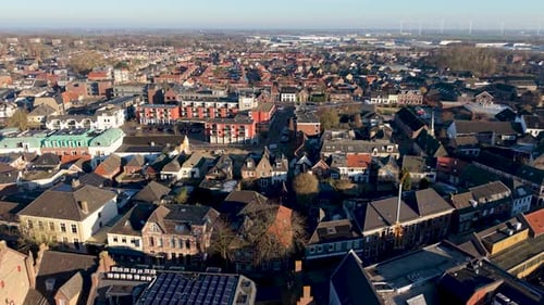 Aerial view of Dutch town red brick homes, solar rooftops, standout red white apartment block