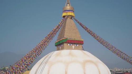 Tilt Down Shot Of An Old Boudhanath Stupa In Kathmandu, Nepal Under The Clear Blue Sky - Tilt Down S