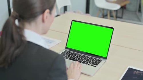 Businesswoman Working on Laptop with Green Chroma Screen