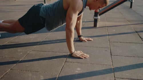Man Performing PushUps Outdoors in an Urban Fitness Park Setting
