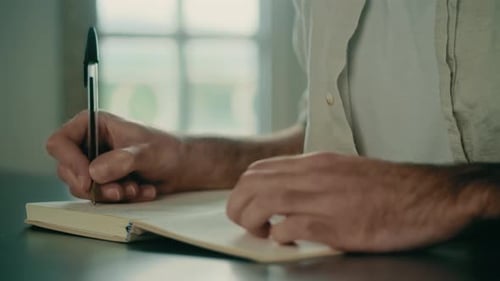 Adult Writing in a Notebook Close-Up