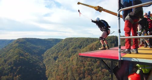 A man base jumping off fayetteville Tennessee bridge with parachute slow motion