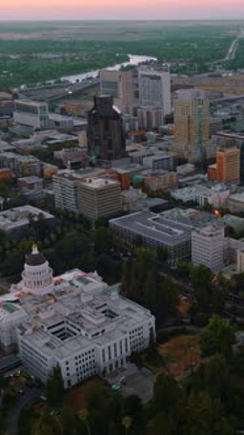 Modern architecture of Sacramento downtown in the evening. River and green landscape at backdrop.