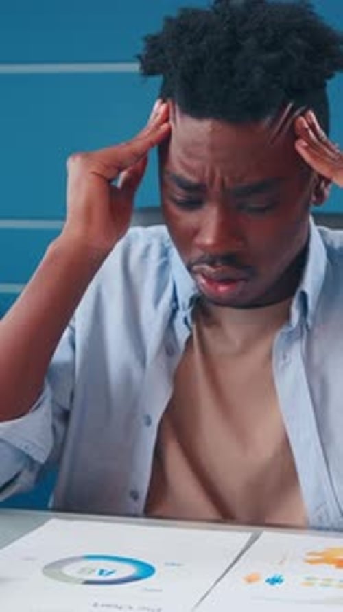 A Young Man Experiences Stress While Studying for Exams in a Quiet Room