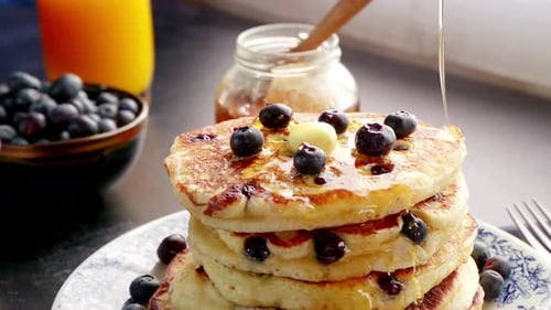 Syrup Drizzling Over a Stack of Fresh Blueberry Pancakes